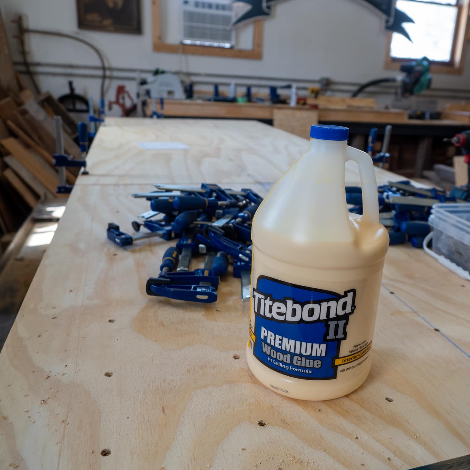 Titebond II premium wood glue in a workshop with a pile of clamps in the background