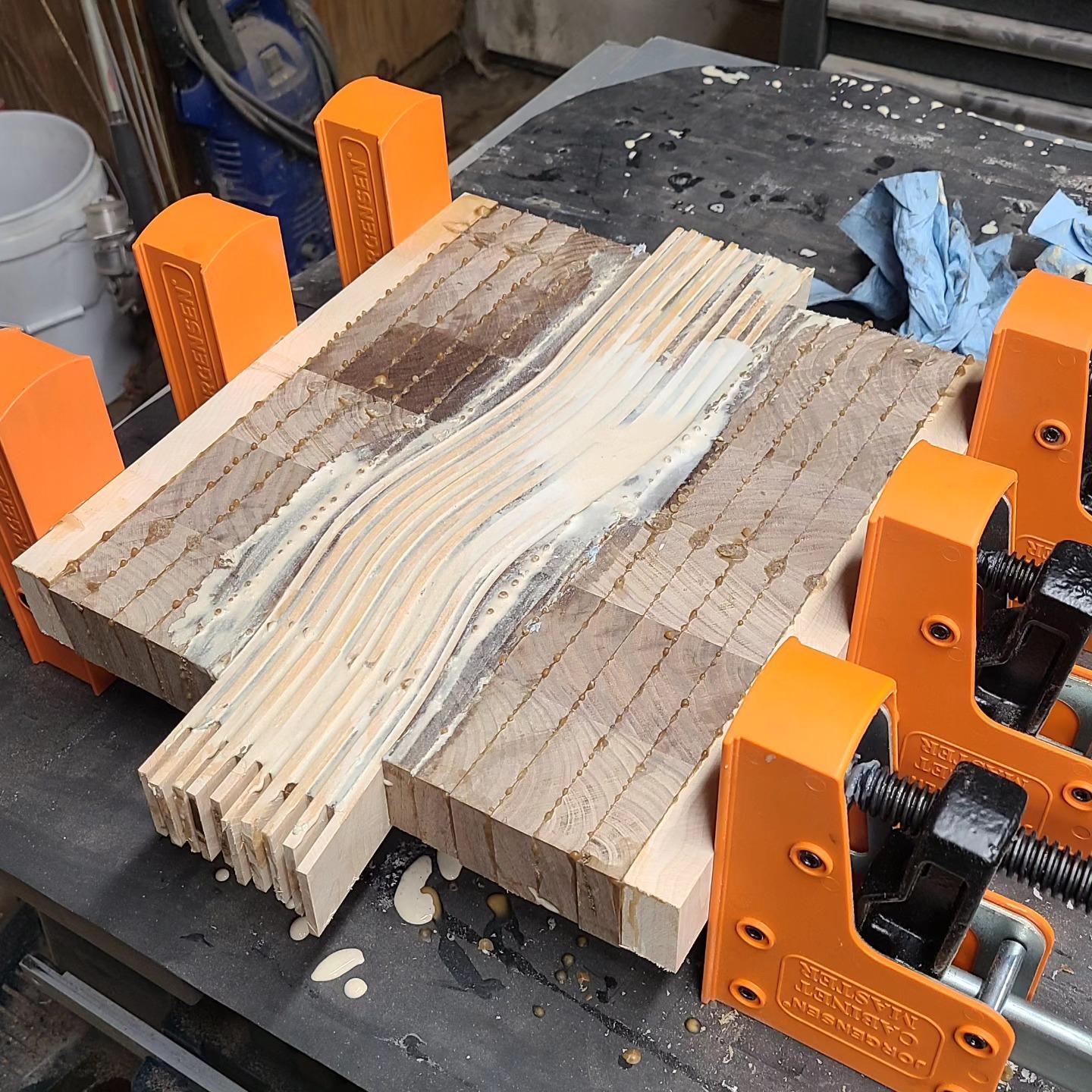 Multiple layers of wood being glued and compressed together