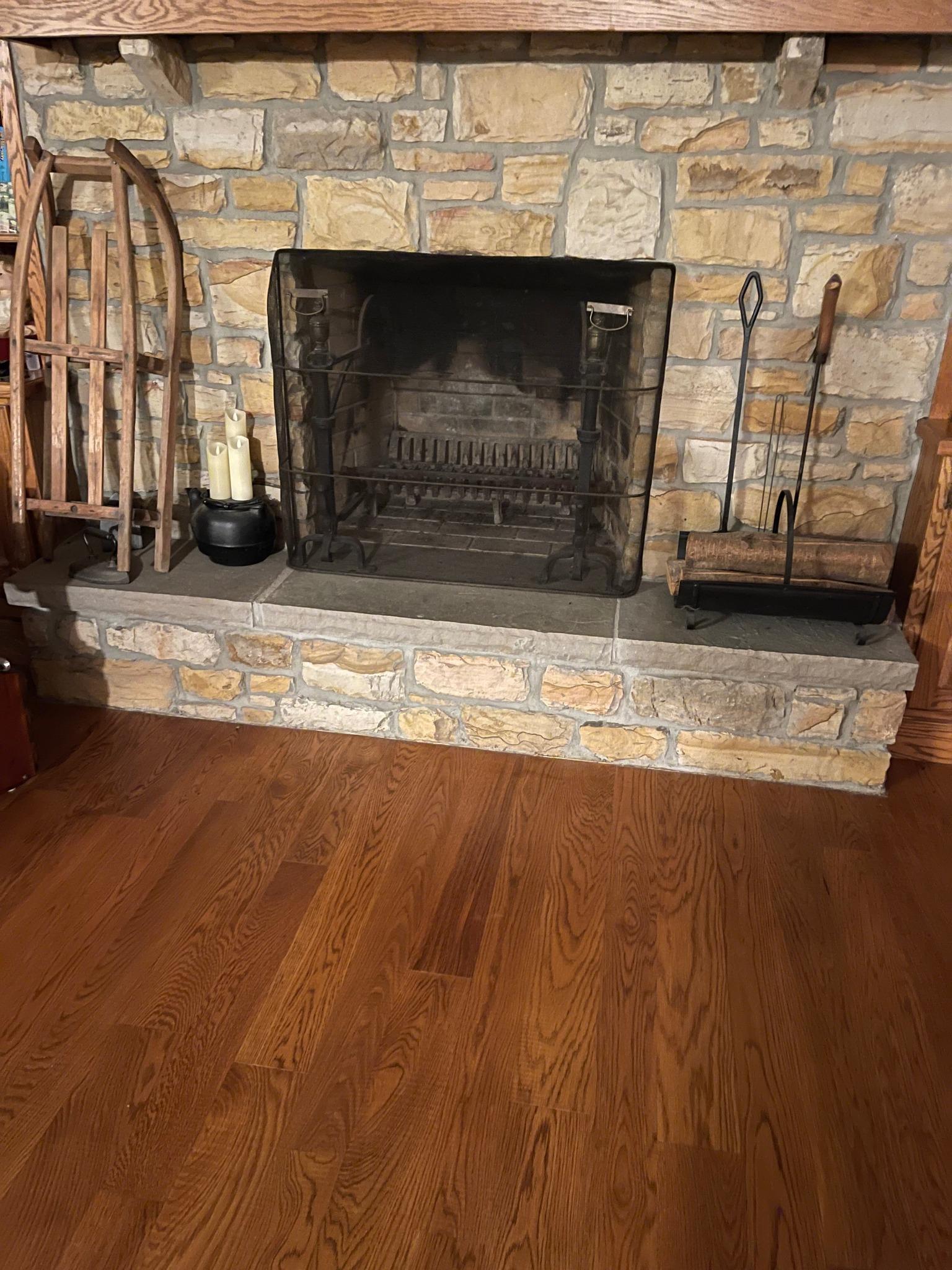 fireplace surrounded by wood flooring