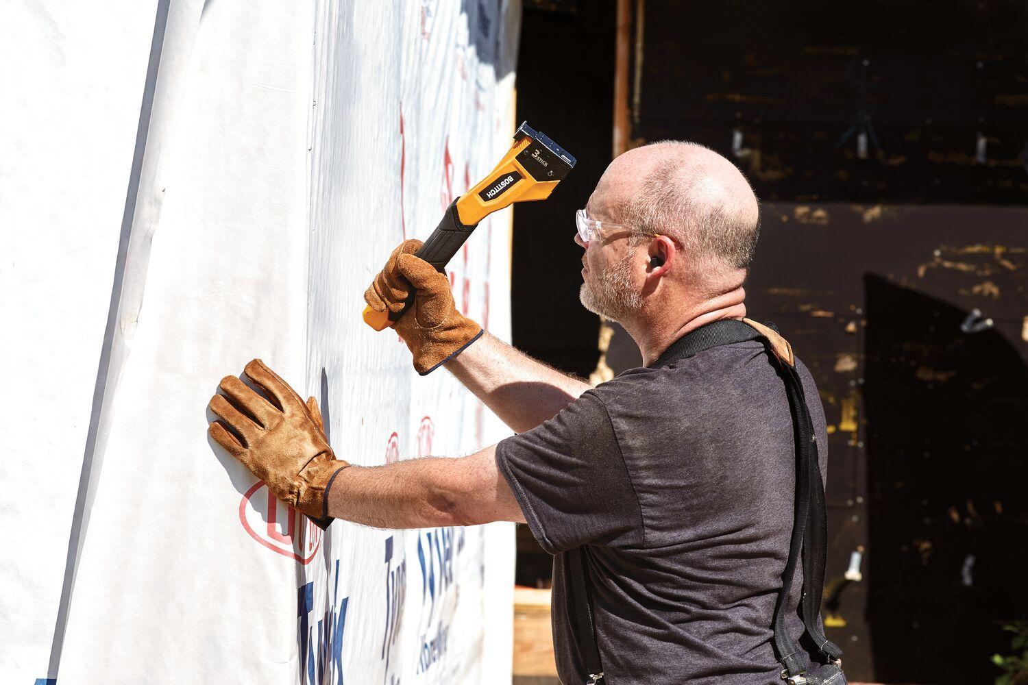 Bostich hammer being used on house wrap