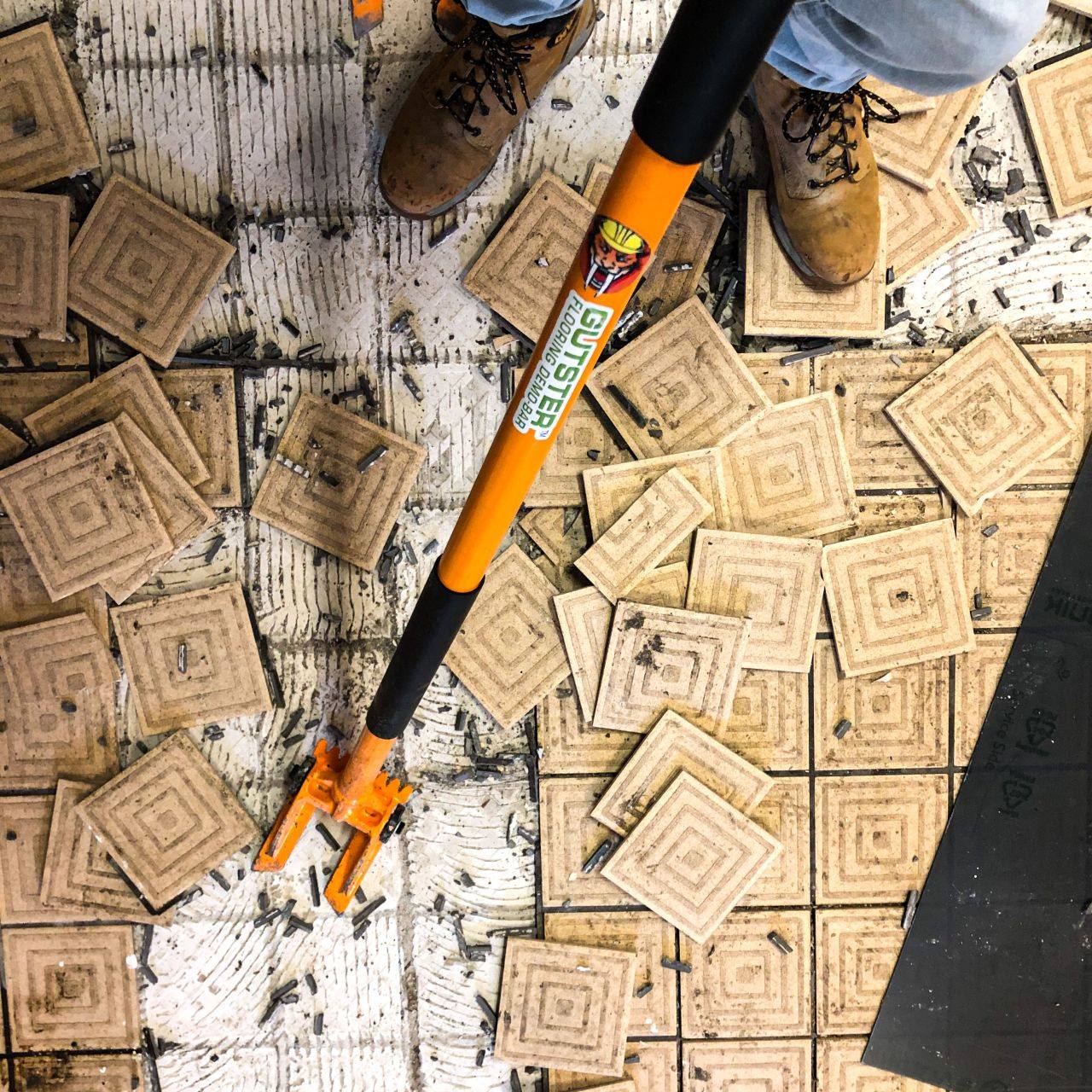 Demolition bar being used to pluck tile