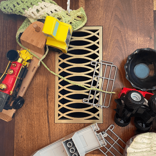 Antique gold curved floor vent with childrens toys surrounding it