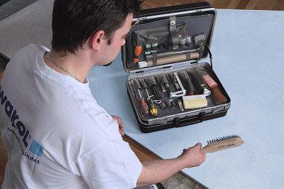 Man holding a brush in front of a tool set